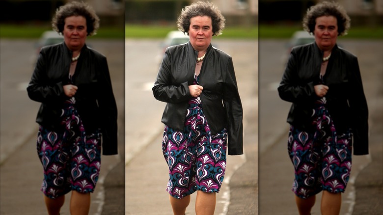Susan Boyle walks wearing a geometric dress and a leather jacket