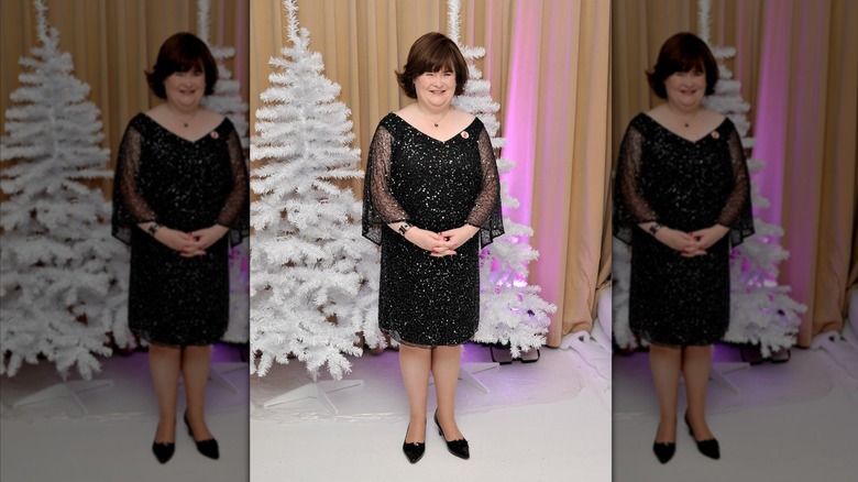 Susan Boyle smiles wearing a black sequin dress