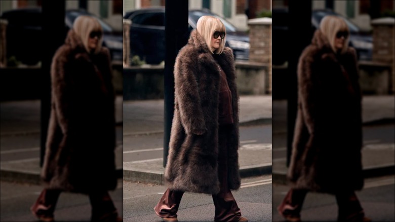Susan Boyle walks wearing a brown fur coat and black sunglasses