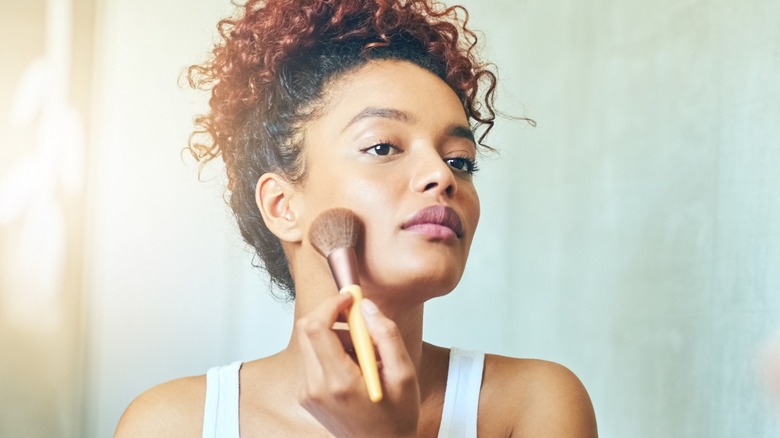 Woman using makeup brush