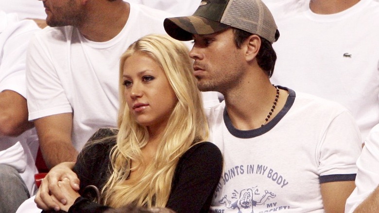 Anna Kournikova and Enrique Iglesias hold hands while watching a basketball game