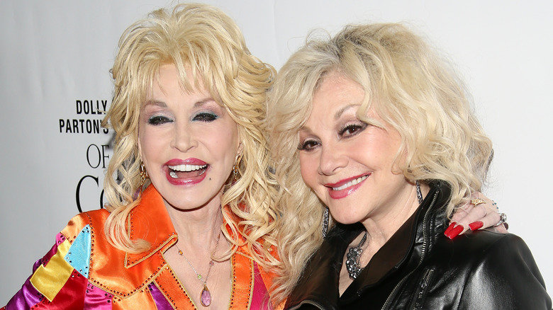 Dolly Parton laughs while posing with sister Stella on the red carpet.
