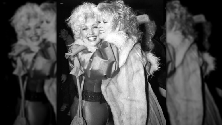 Side-by-side photos show Dolly Parton and her sister Rachel hugging in a black-and-white shot (left) and posing together in 2024 (right).