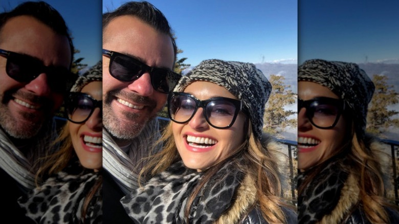 Shane Farley and Giada De Laurentiis smile in front of a snowy backdrop