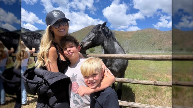 Christina Haack with Brayden and Hudson posing next to horses at a ranch.