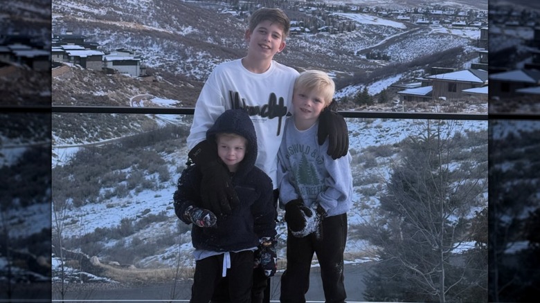 Christina Haack's son Brayden with his two half brothers posing outdoors dressed in cold-weather clothes.
