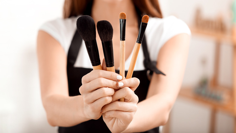girl holding makeup brushes
