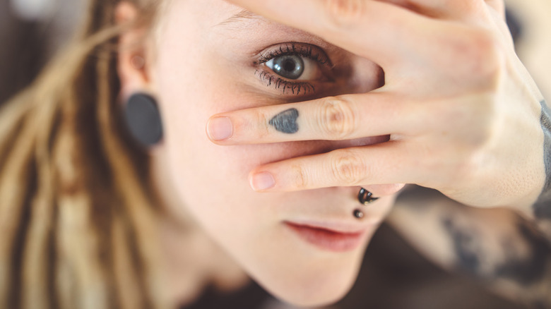 woman with piercings and finger tattoo