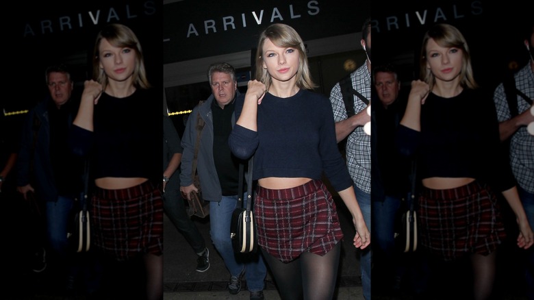 Taylor Swift arriving at LAX while wearing a plaid miniskirt