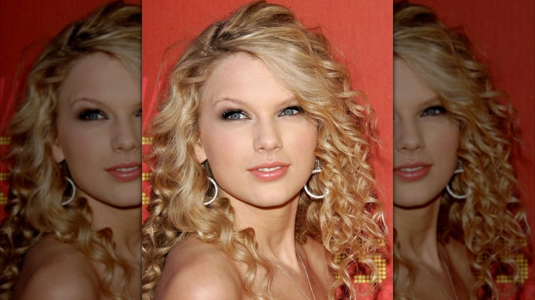 Taylor Swift with hoop earrings, smoky eyes, and a nude lip at a red carpet event in 2007.
