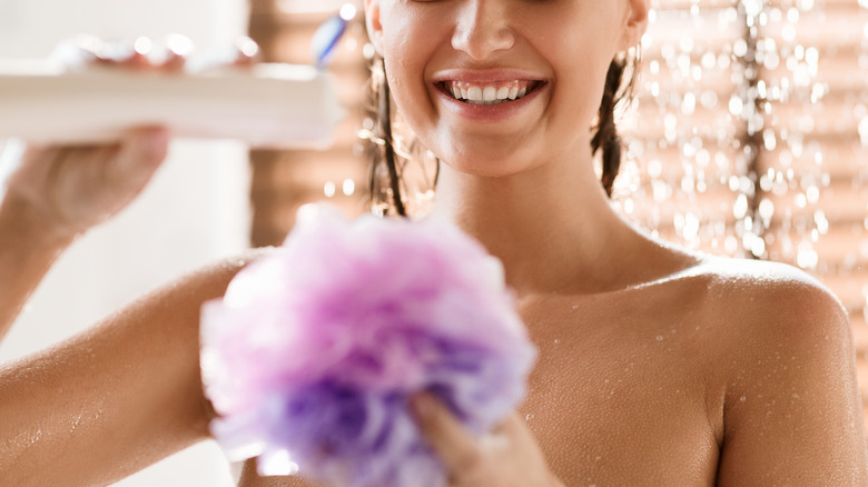 Woman using body wash smiling