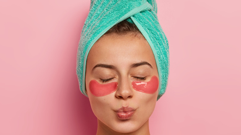 Woman with eye patches and a hair towel