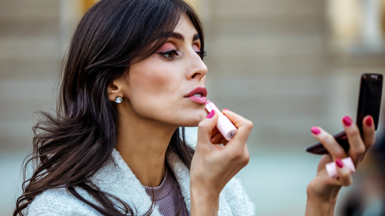 Woman wearing different makeup items