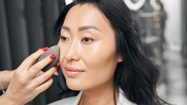 woman applying lightweight skin tint