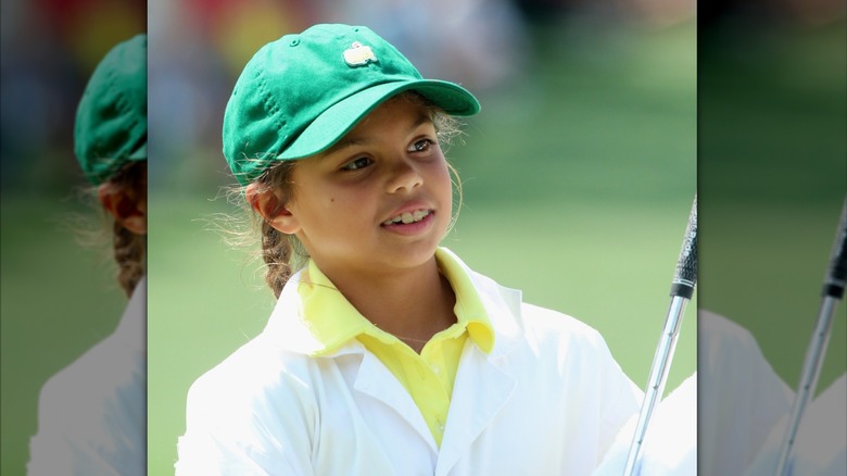 Sam Woods wears her hair in braids under a green Masters cap with a bright yellow shirt while attending the 2015 Masters Tournament in Georgia.