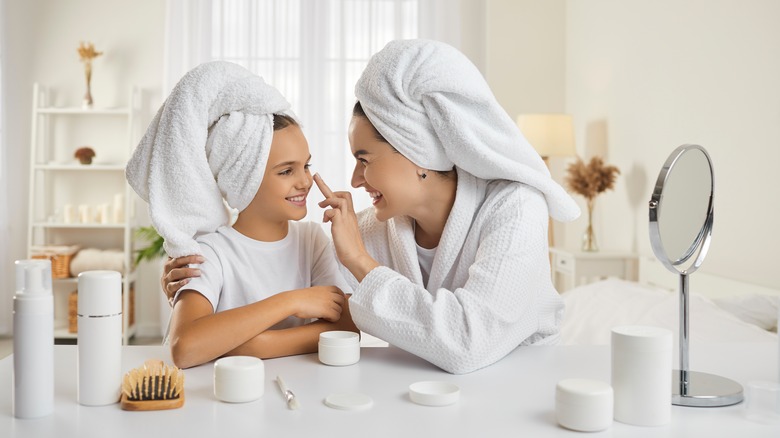 mother and daughter using beauty products