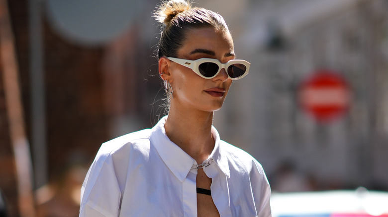 Woman wearing '90s bun and brown lipstick.