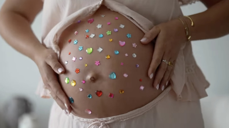 A woman with a bedazzled pregnancy belly