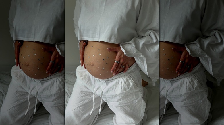 A woman with a bedazzled pregnancy belly