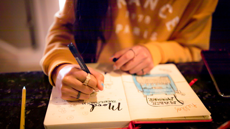 Woman writing in bullet journal