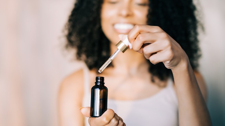 Woman holding bottle of oil