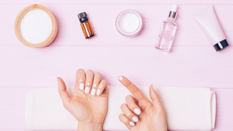 woman applying lotion to nails