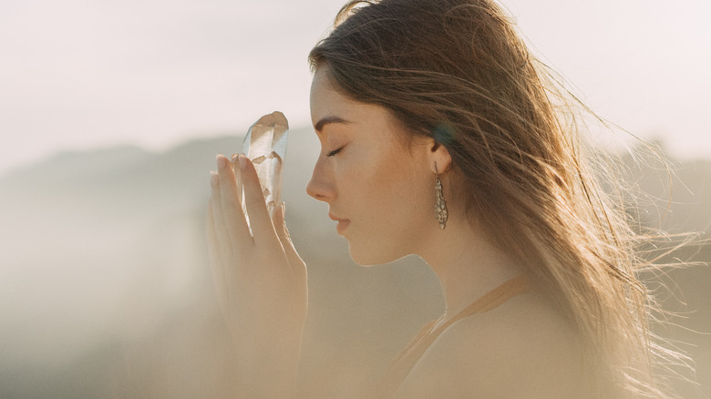 Woman holding clear quartz crystal 