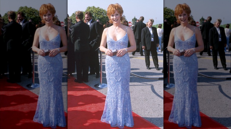 Reba McEntire posing on a red carpet in a blue spaghetti-strap dress at the 2000 ACM Awards.