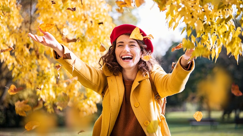 Woman catching falling leaves