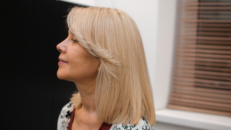 Mature woman with blond lob and curtain bangs