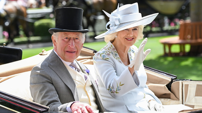 King Charles III and Queen Camilla smile and wave as they attend day one of Royal Ascot 2026 at Ascot Racecourse on June 16, 2026
