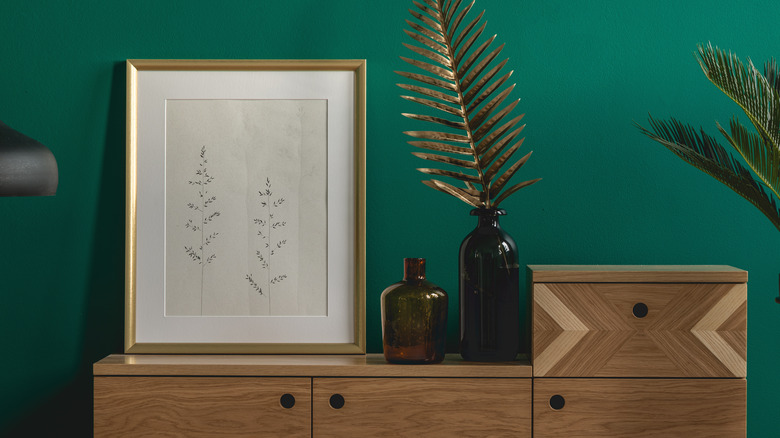 dresser with a large framed painting