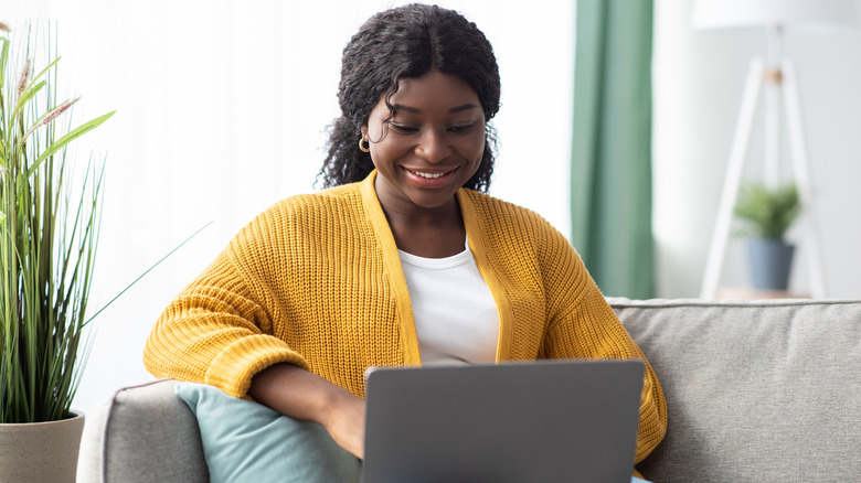 Woman yellow cardigan laptop 