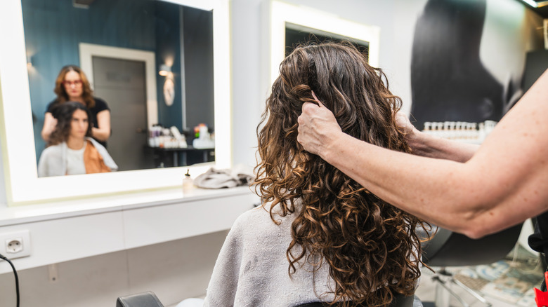 A woman with irish curls getting a haircut from a professional