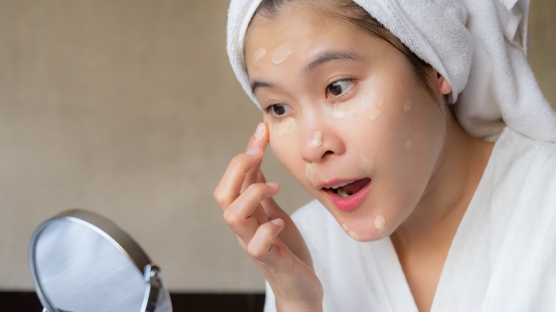 Woman applying concealer