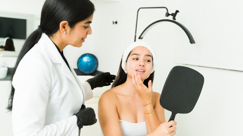 A patient and a surgeon discussing her facial features