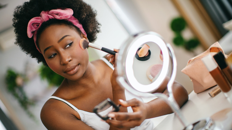 woman applying powder blush