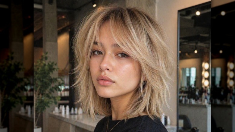 A woman poses after getting a butterfly bob