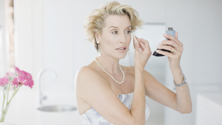 Woman applying powder foundations
