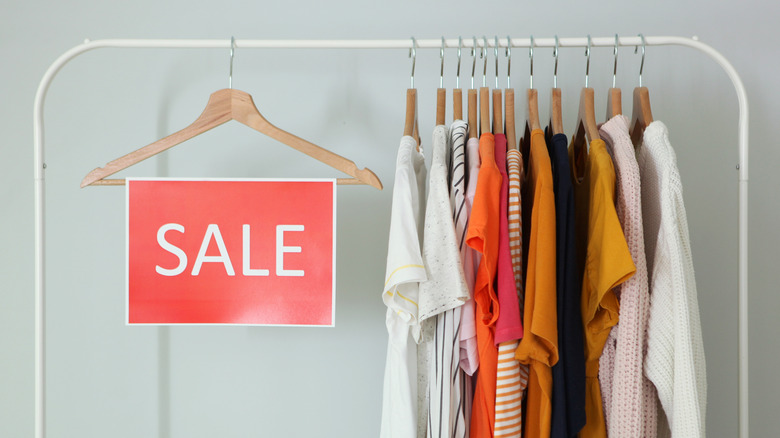 Rack of discounted clothing with sale sign