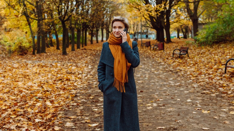 woman on phone with coat and scarf