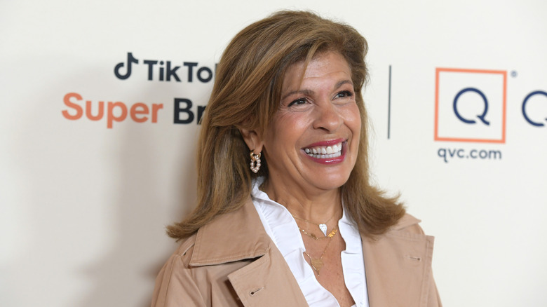 Hoda Kotb in 2025 smiling in front of a media wall