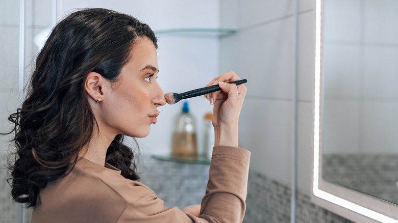 Woman applying contour on nose