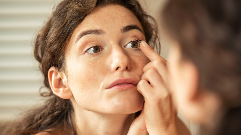 Person putting in contact lenses