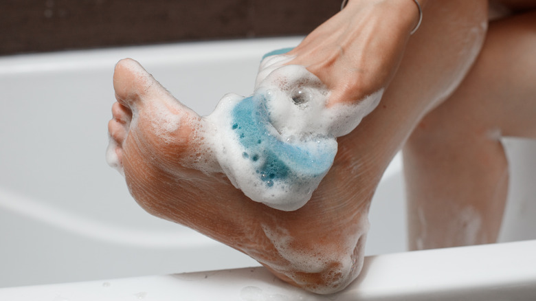 woman washing feet in shower