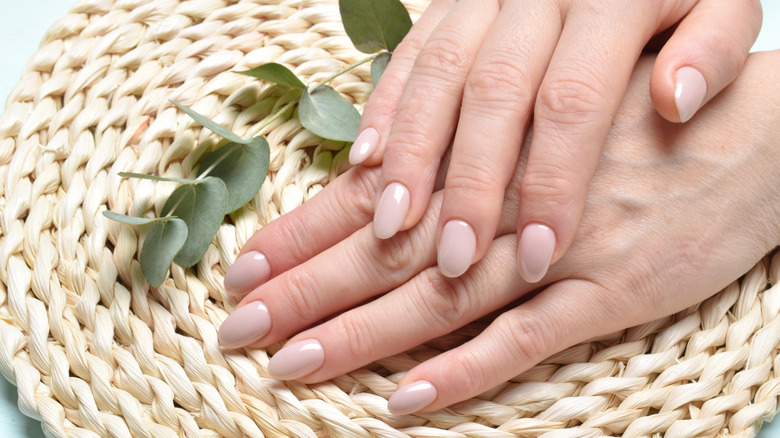 Hands with plain rounded cream nails