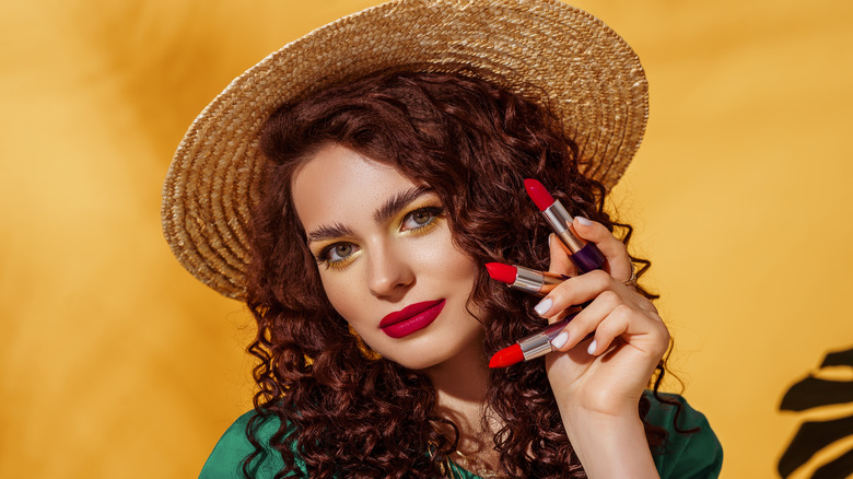 Woman holding lipstick tubes
