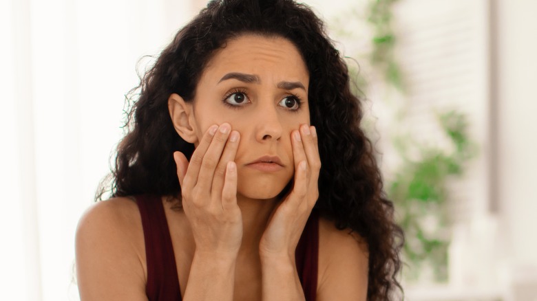 Woman looking at eyes in mirror