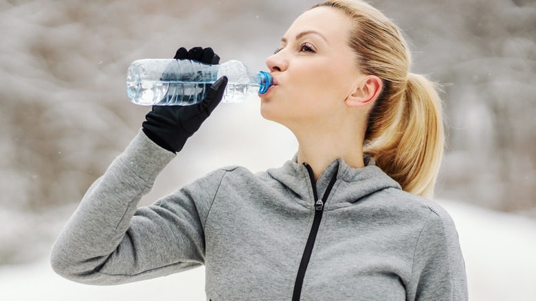 Model drinking water during workout in winter