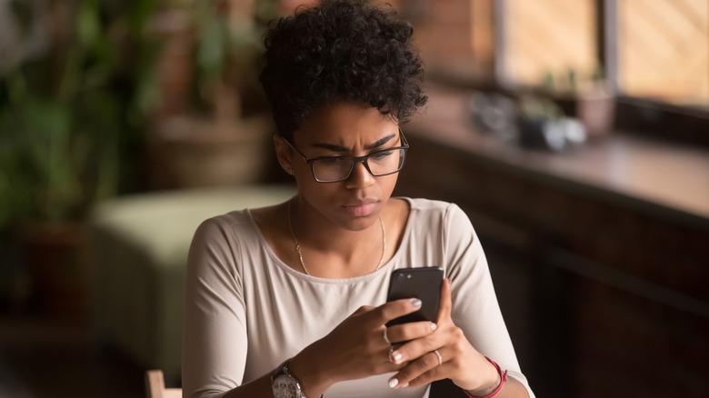 woman using phone at table